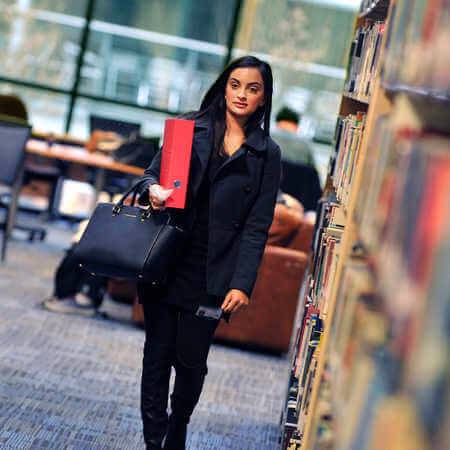 female student walking in library