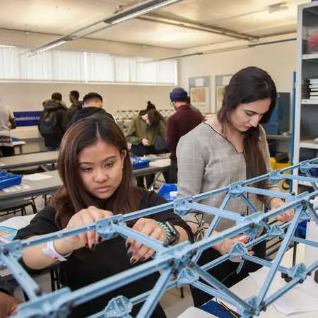 two undergraduate civil engineering students working on a bridge structure