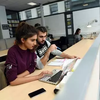 Two computer science students working on laptop