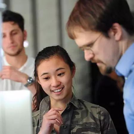 a smiling student and a bespectacled lecturer look at a screen at the Digital Design show