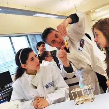 male lecturer explaining an experiment to two students in a science laboratory at 果冻传媒麻豆社