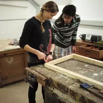 Asian man with woman creating in a workshop
