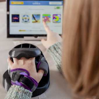 woman using the neuroball and pointing at the tablet