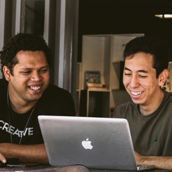 two-men looking at a macbook