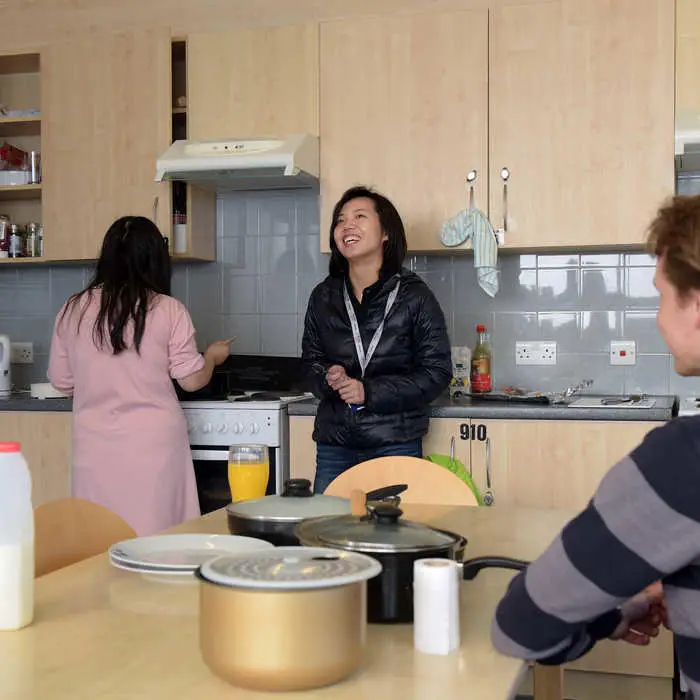 Three students in the kitchen of student accommodation.