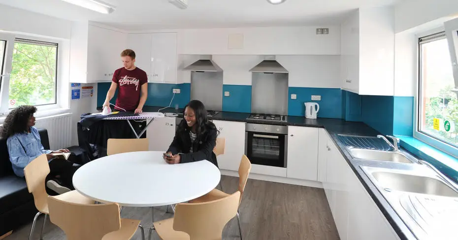Brunel students chatting in the kitchen of student accommodation. 