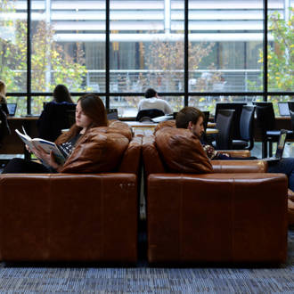 two students reading in the library autrium