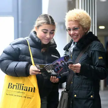 Student and parent looking at a booklet at the Brunel Open Day
